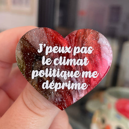 Broche "J'peux pas le climat politique me déprime" en acrylique marbrée rouge, marron, verte et blanche