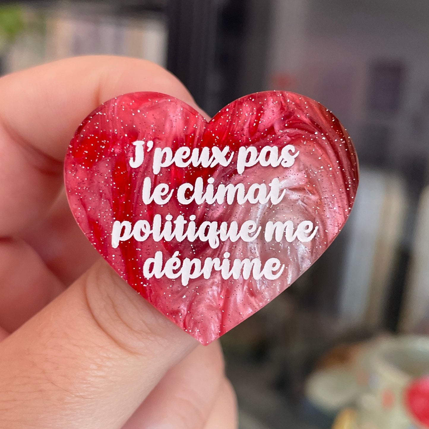 Broche "J'peux pas le climat politique me déprime" en acrylique marbrée rouge, marron, verte et blanche