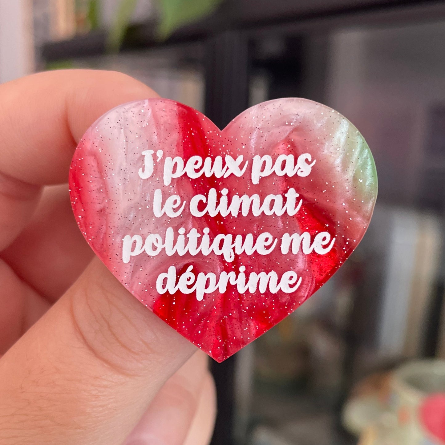 Broche "J'peux pas le climat politique me déprime" en acrylique marbrée rouge, marron, verte et blanche