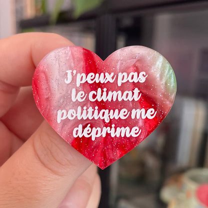 Broche "J'peux pas le climat politique me déprime" en acrylique marbrée rouge, marron, verte et blanche