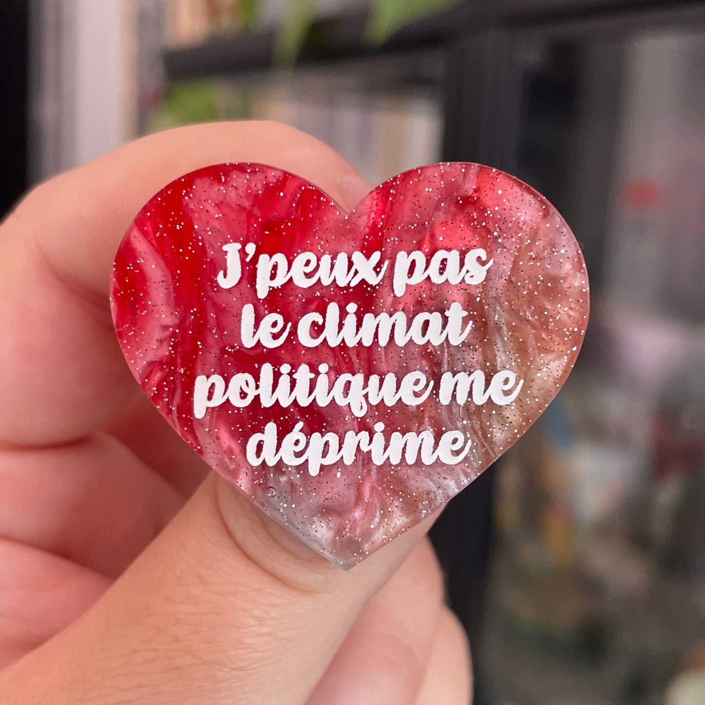 Broche "J'peux pas le climat politique me déprime" en acrylique marbrée rouge, marron, verte et blanche