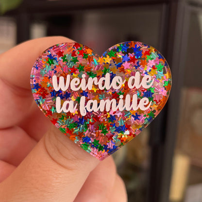 Broche "Weirdo de la famille" en acrylique semi-transparente avec des confettis étoiles multicolores