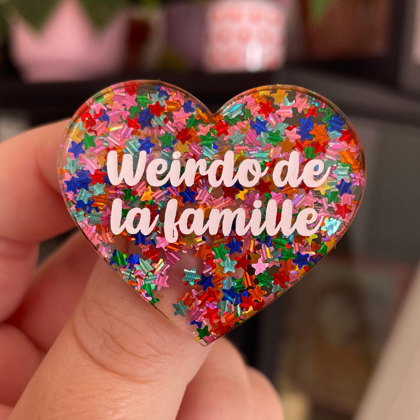 Broche "Weirdo de la famille" en acrylique semi-transparente avec des confettis étoiles multicolores