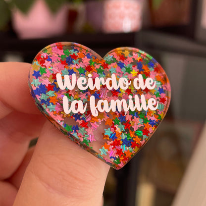 Broche "Weirdo de la famille" en acrylique semi-transparente avec des confettis étoiles multicolores