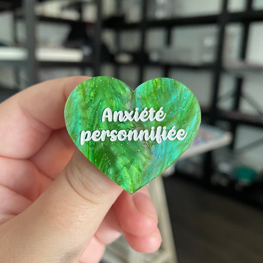 Broche "Anxiété personnifiée" en acrylique marbrée verte à paillettes