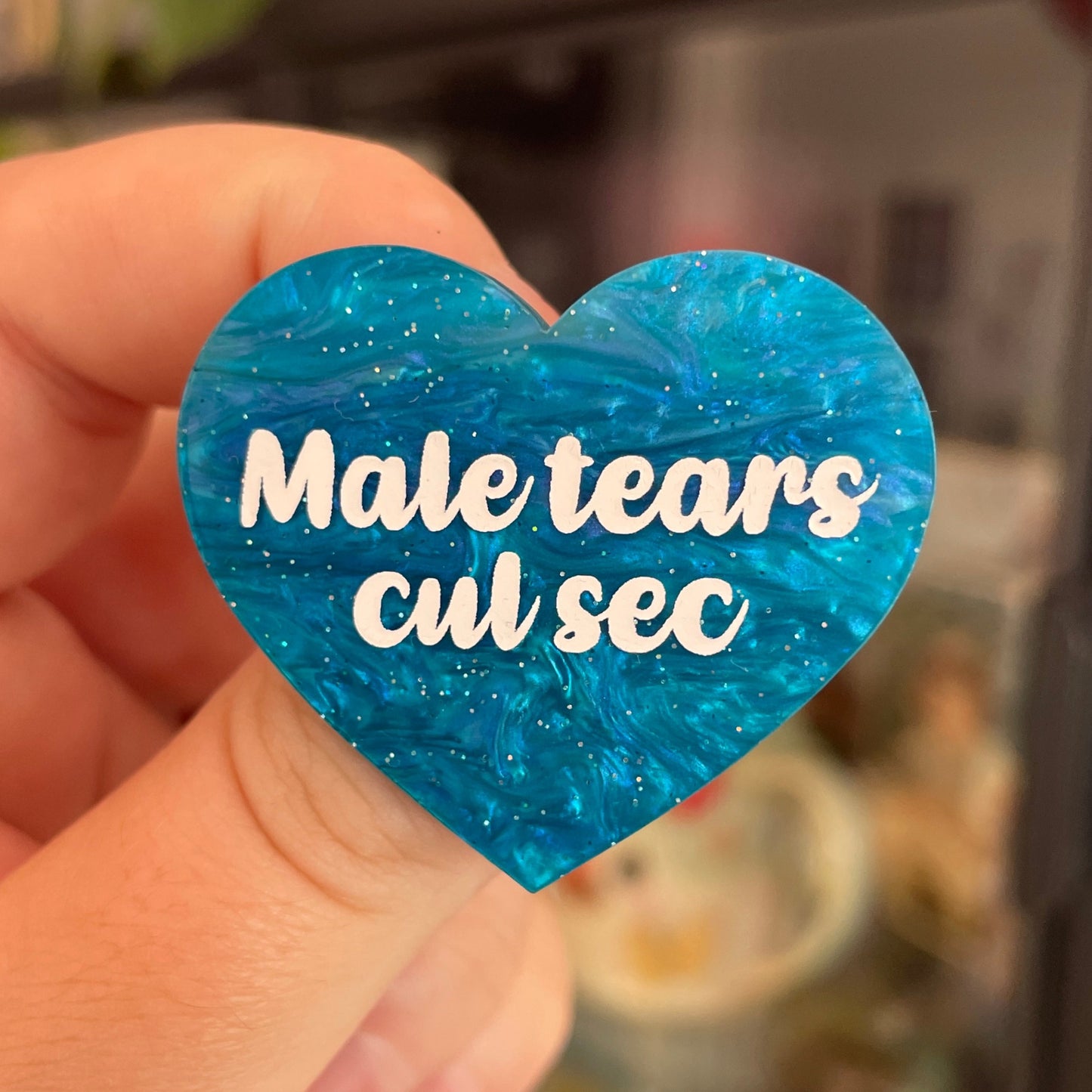 Broche "Male tears cul sec" en acrylique marbrée bleue à paillettes