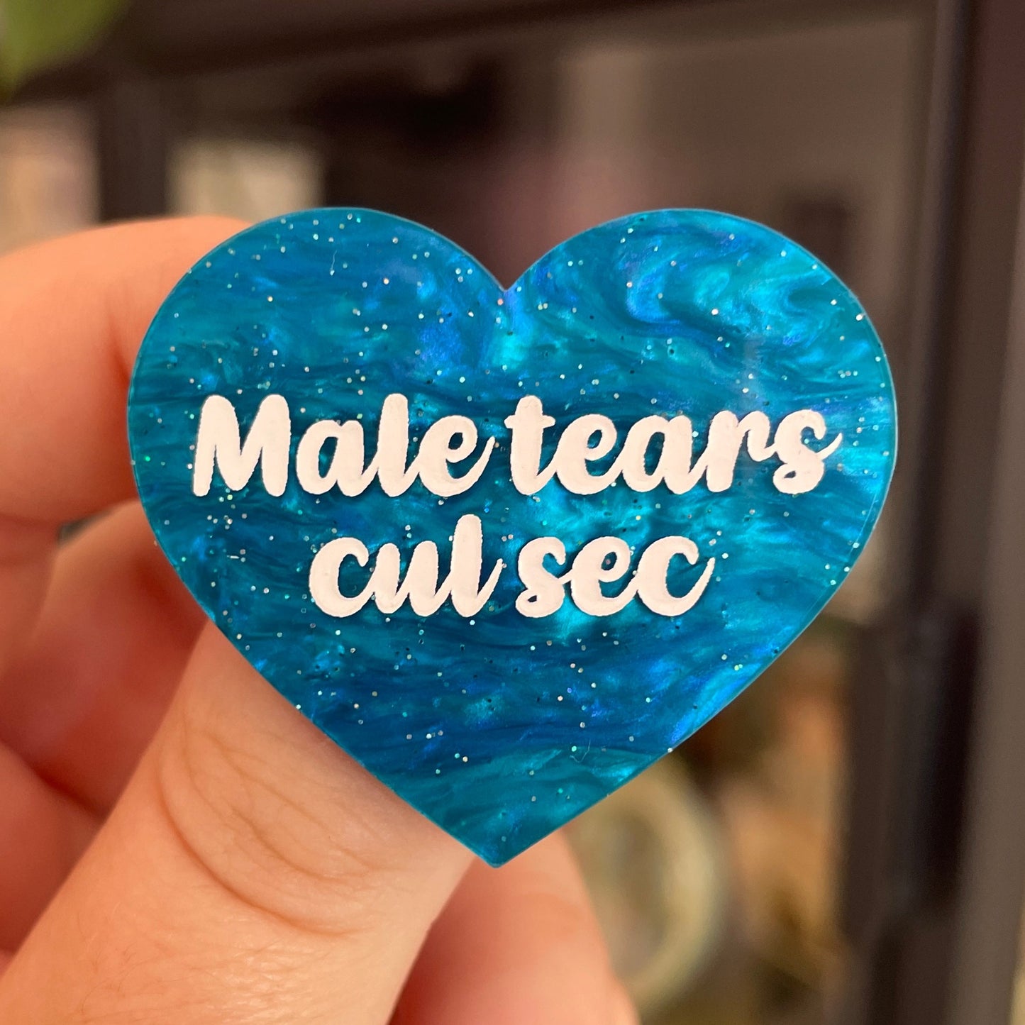 Broche "Male tears cul sec" en acrylique marbrée bleue à paillettes
