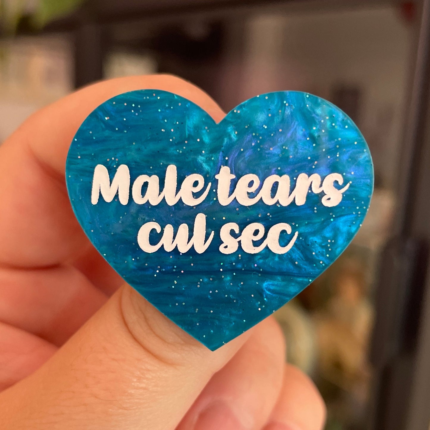 Broche "Male tears cul sec" en acrylique marbrée bleue à paillettes