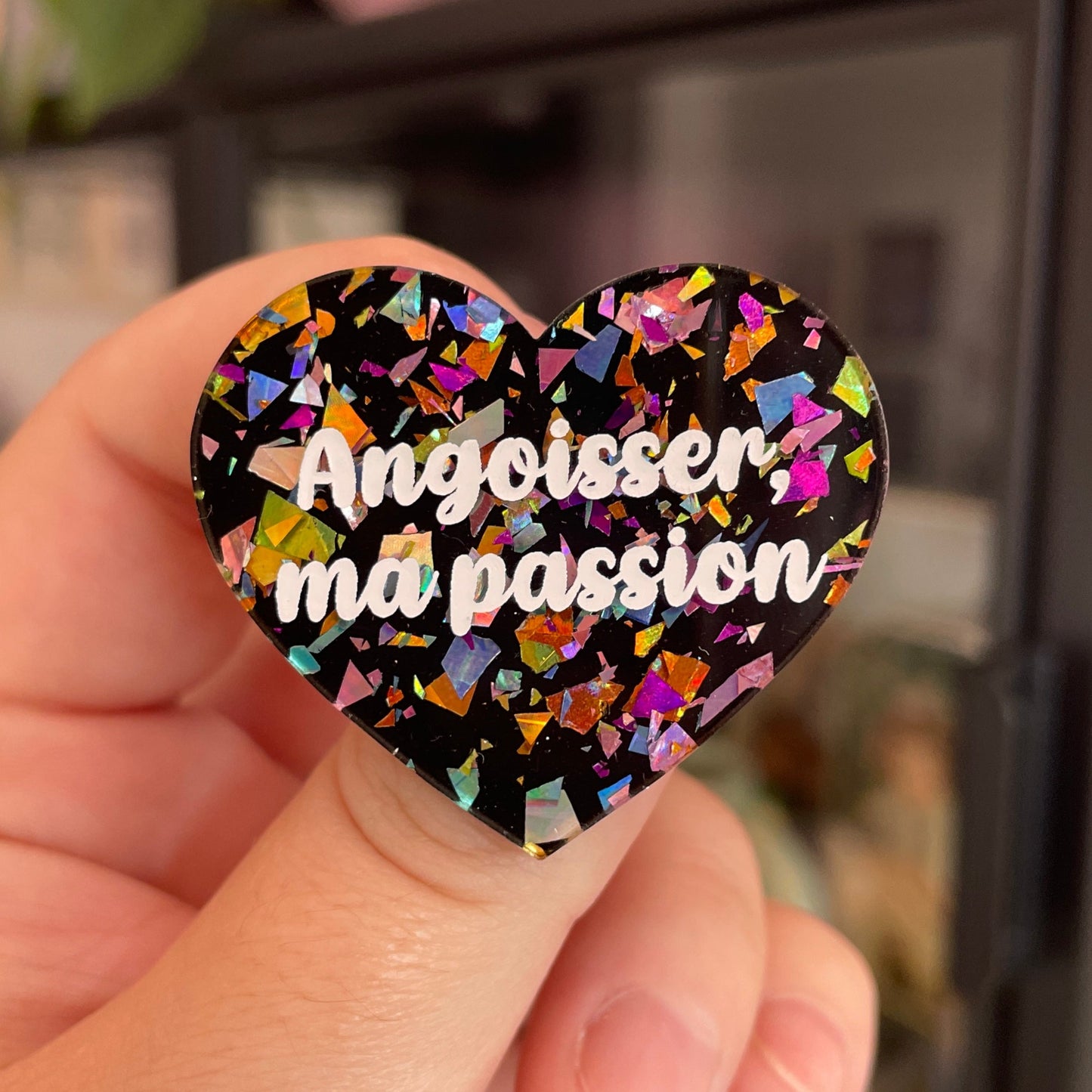 Broche "Angoisser, ma passion" en acrylique noire avec des éclats de confettis multicolores