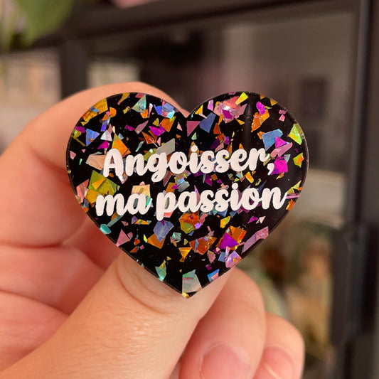 Broche "Angoisser, ma passion" en acrylique noire avec des éclats de confettis multicolores