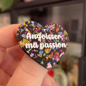 Broche "Angoisser, ma passion" en acrylique noire avec des éclats de confettis multicolores