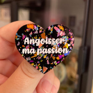 Broche "Angoisser, ma passion" en acrylique noire avec des éclats de confettis multicolores