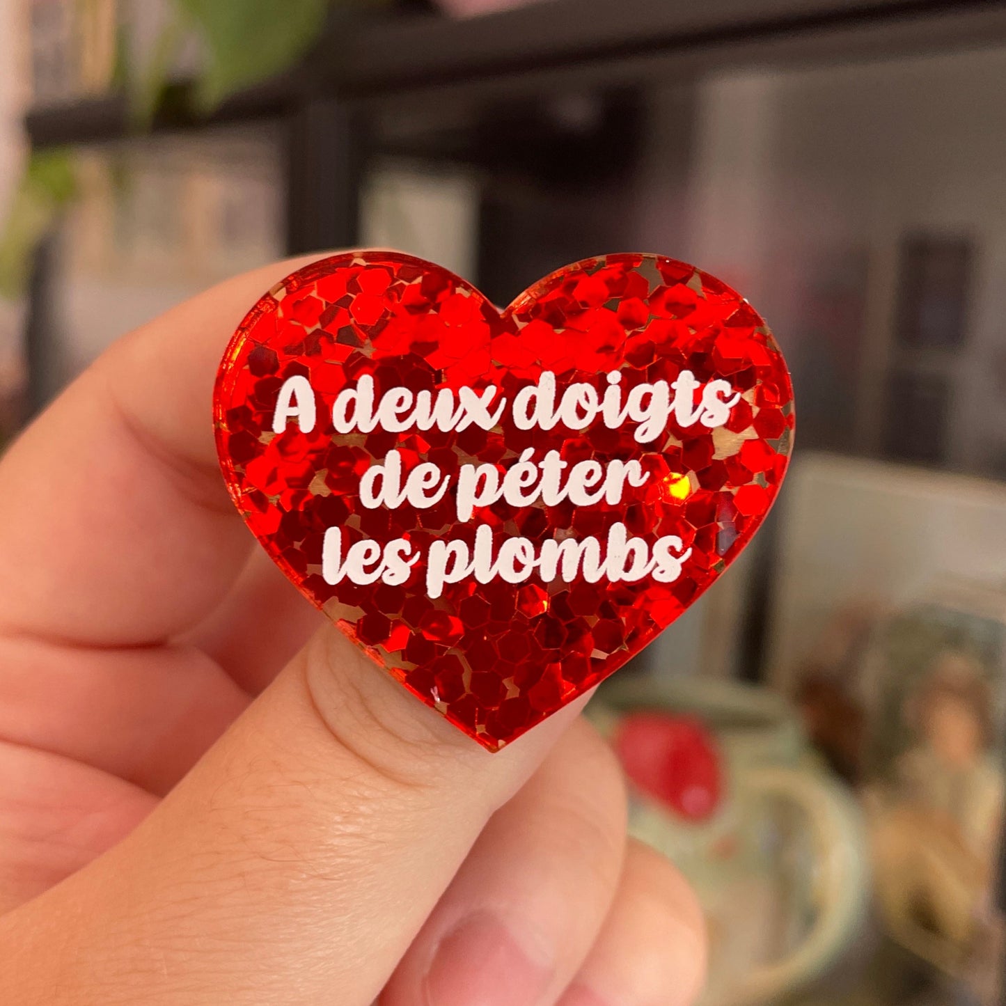 Broche "A deux doigts de péter les plombs" en acrylique semi-transparente avec des confettis rouges