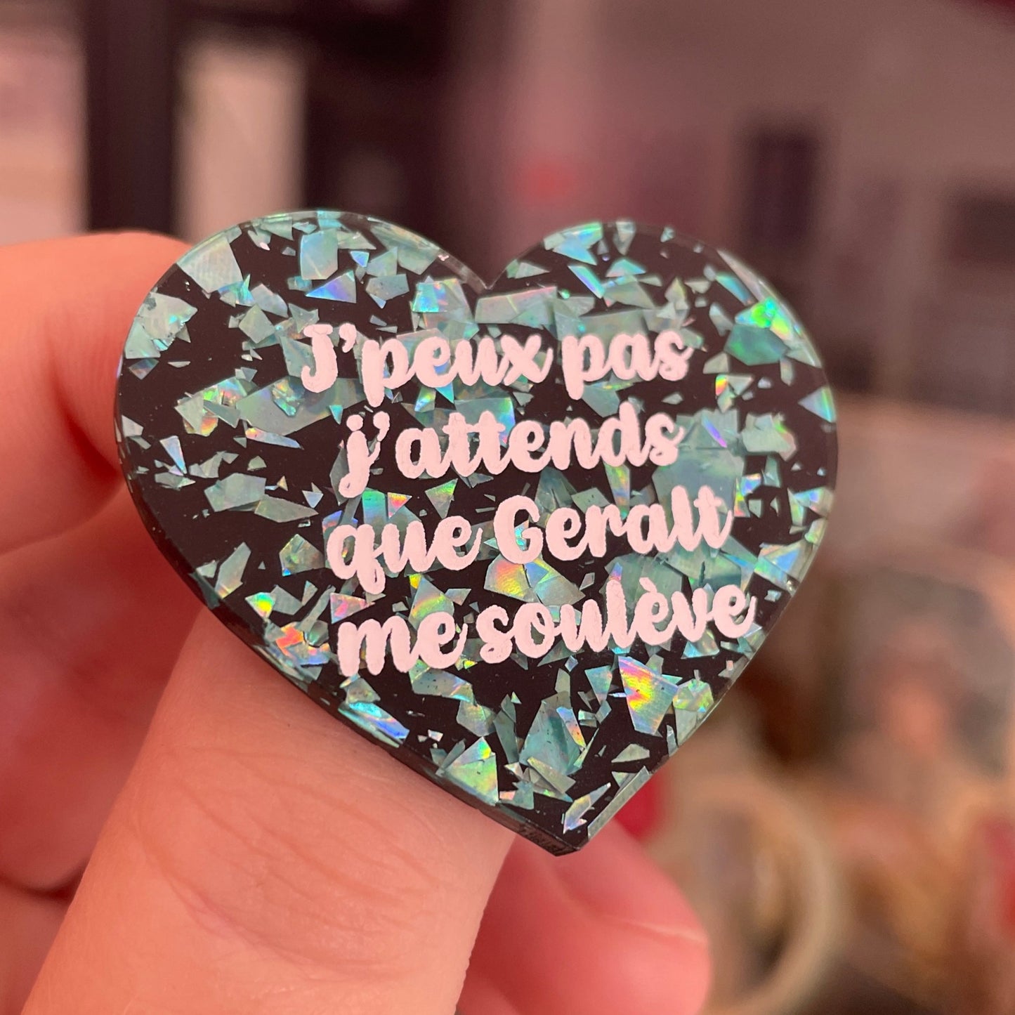 Broche "J'peux pas j'attends que Geralt me soulève" en acrylique noire avec des éclats de confettis turquoise