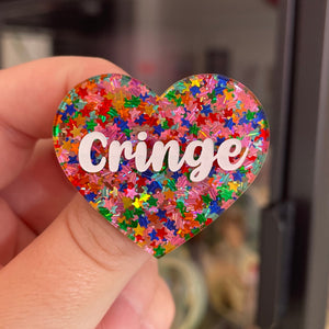 Broche "Cringe" en acrylique semi-transparente avec des confettis étoiles multicolores