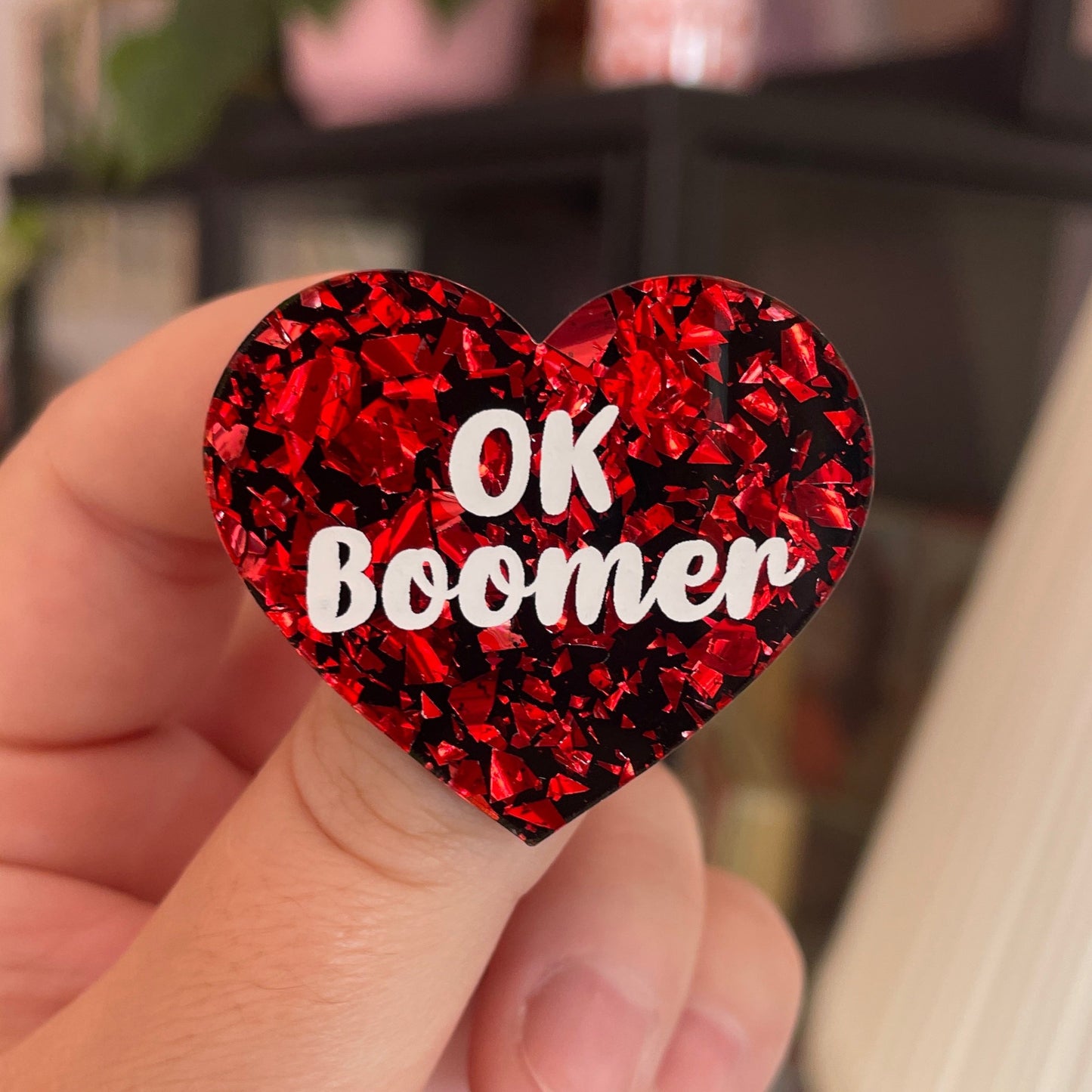 Broche "OK Boomer" en acrylique noire avec des éclats de confettis rouges