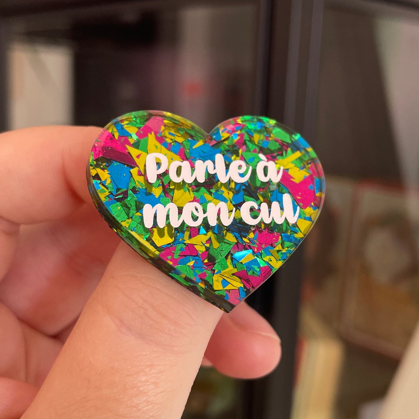 Broche "Parle à mon cul" en acrylique transparente à gros confettis verts, roses, jaunes et bleus