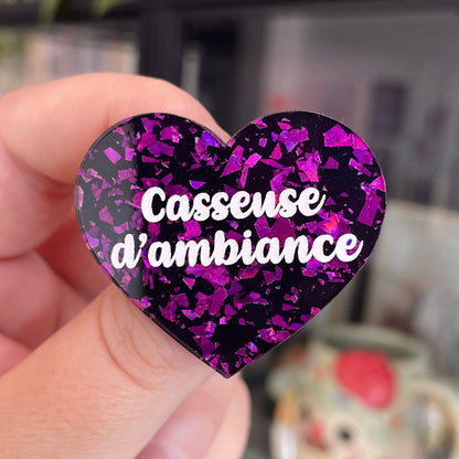Broche "Casseuse d'ambiance" en acrylique noire avec des éclats de confettis violets