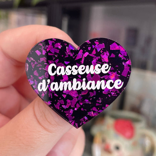 Broche "Casseuse d'ambiance" en acrylique noire avec des éclats de confettis violets