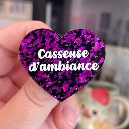 Broche "Casseuse d'ambiance" en acrylique noire avec des éclats de confettis violets