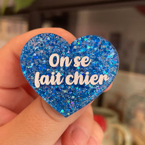 Broche "On se fait chier" en acrylique pailletée bleue et argentée