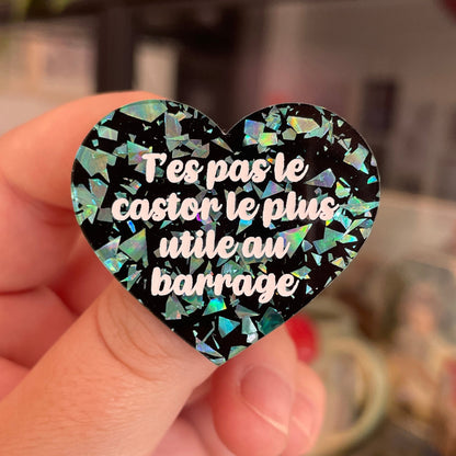 Broche "T'es pas le castor le plus utile au barrage" en acrylique noire avec des éclats de confettis turquoise