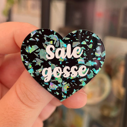 Broche "Sale gosse" en acrylique noire avec des éclats de confettis turquoise