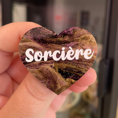 Broche "Sorcière" en acrylique marbrée noire, dorée et violette à paillettes