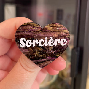 Broche "Sorcière" en acrylique marbrée noire, dorée et violette à paillettes