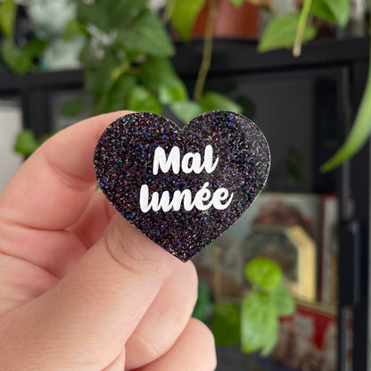 Broche "Mal lunée" en acrylique à paillettes noires holographiques