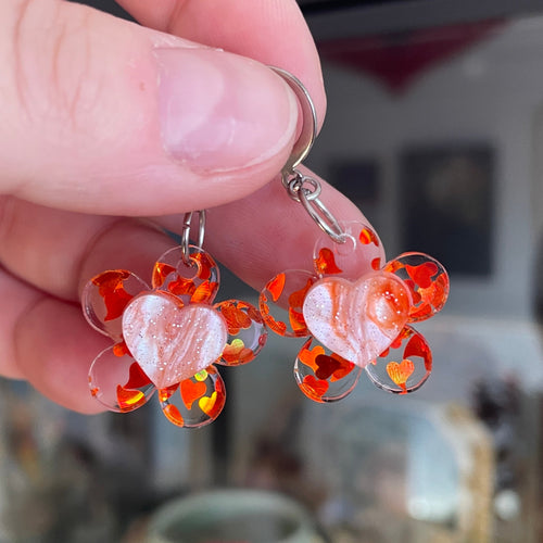 Petites boucles d'oreilles fleurs/coeurs pendantes en acrylique semi transparente avec des coeurs oranges