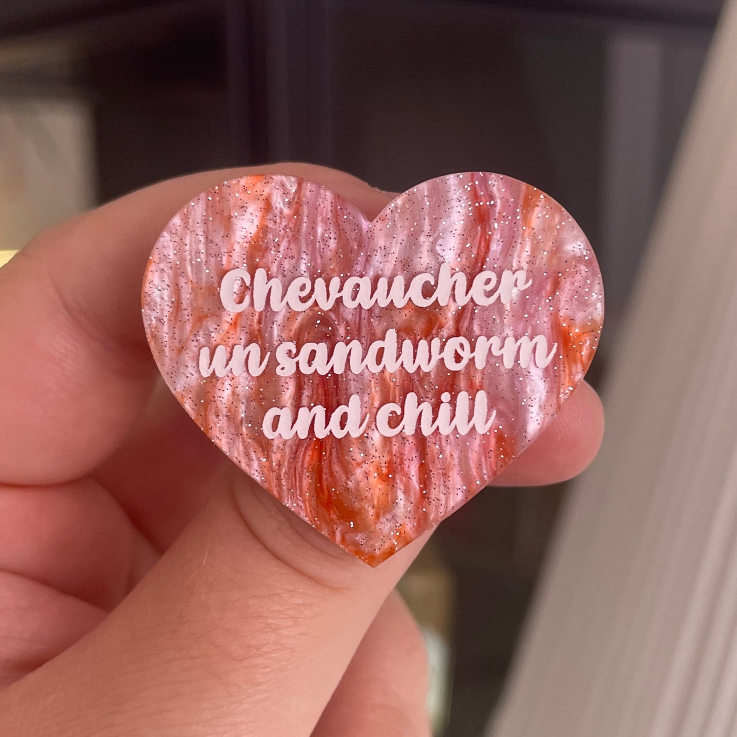 [CONTRÔLE TECHNIQUE] Broche "Chevaucher un sandworm and chill" en acrylique marbrée blanche et orange à paillettes