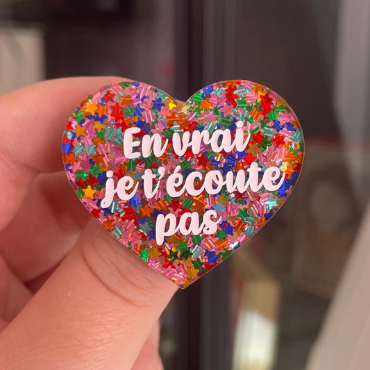 [CONTRÔLE TECHNIQUE] Broche "En vrai je t'écoute pas" en acrylique semi-transparente avec des confettis étoiles multicolores