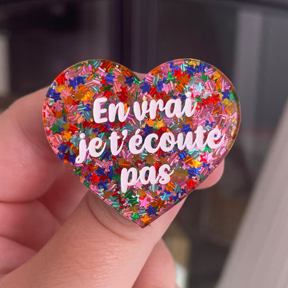 [CONTRÔLE TECHNIQUE] Broche "En vrai je t'écoute pas" en acrylique semi-transparente avec des confettis étoiles multicolores