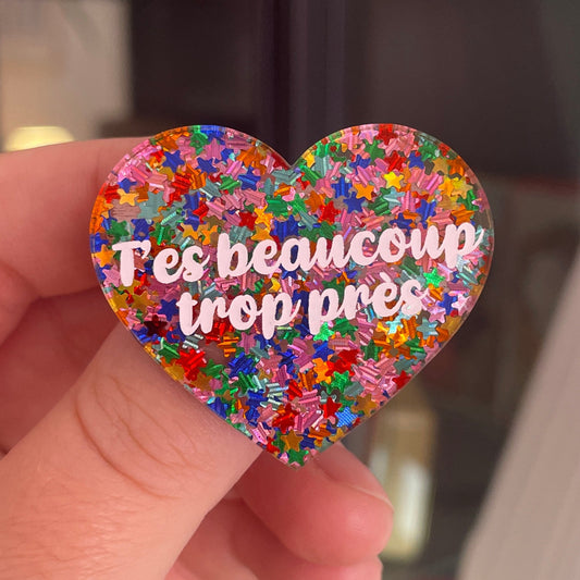 [CONTRÔLE TECHNIQUE] Broche "T'es beaucoup trop près" en acrylique semi-transparente avec des confettis étoiles multicolores