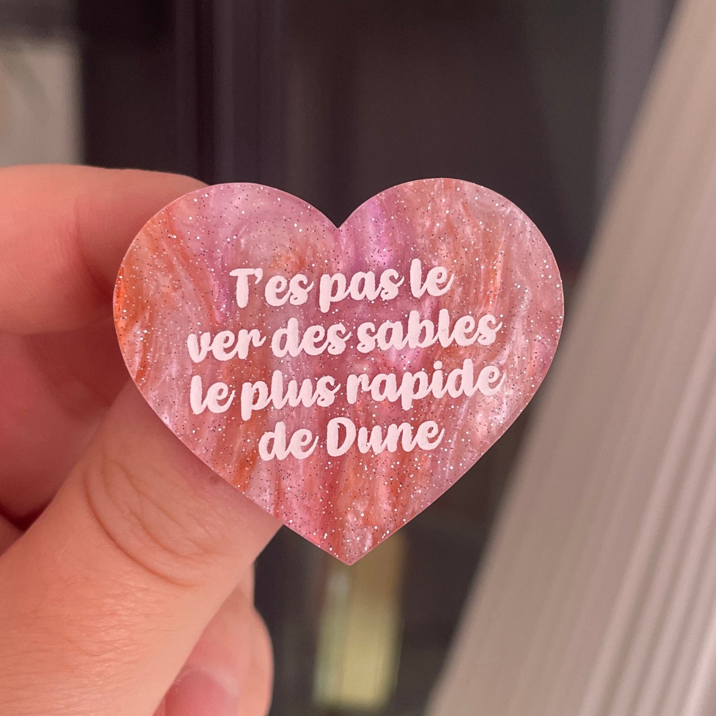 [CONTRÔLE TECHNIQUE] Broche "T'es pas le ver des sables le plus rapide de Dune" en acrylique marbrée blanche et orange à paillettes