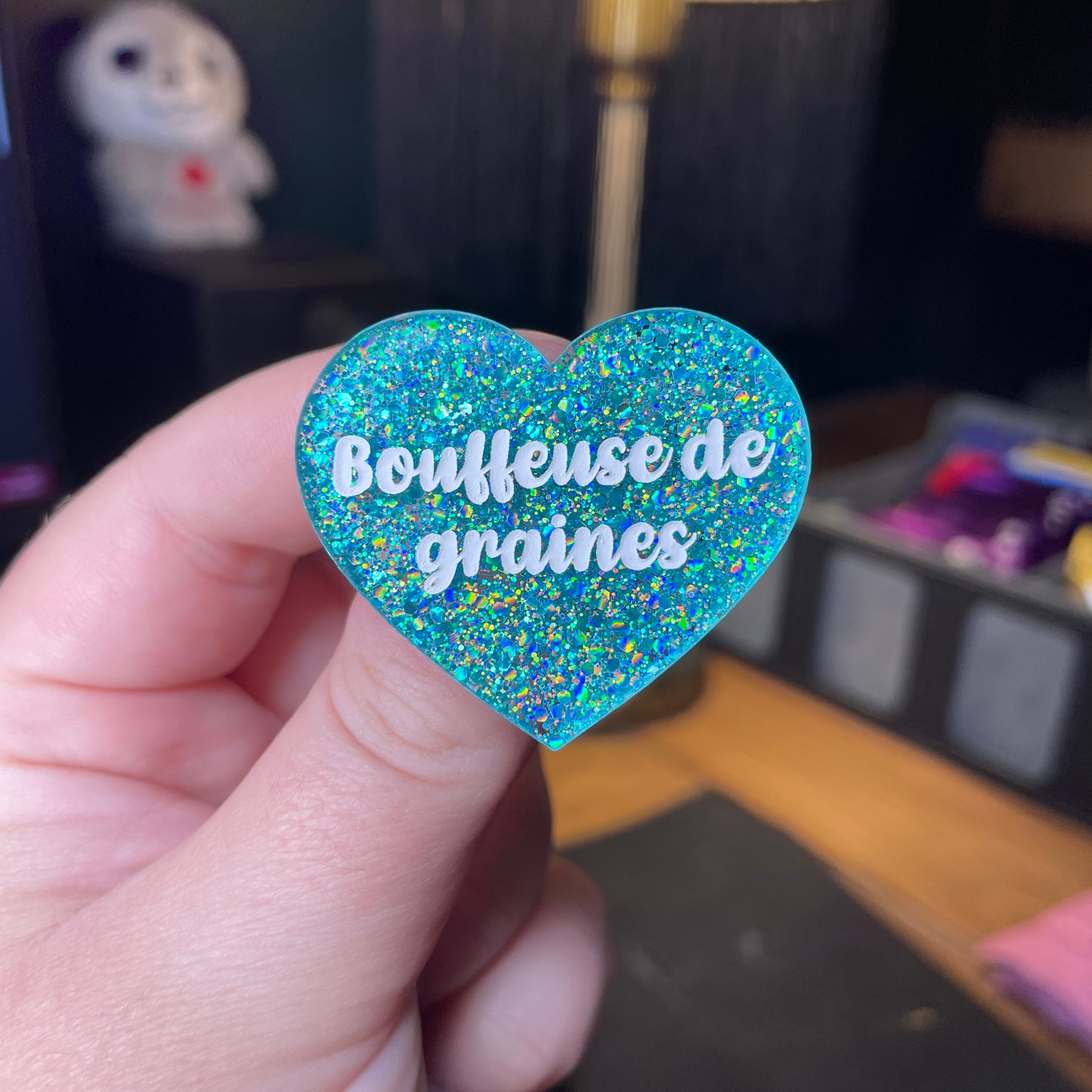 Broche "Bouffeuse de graines" en acrylique à paillettes turquoise