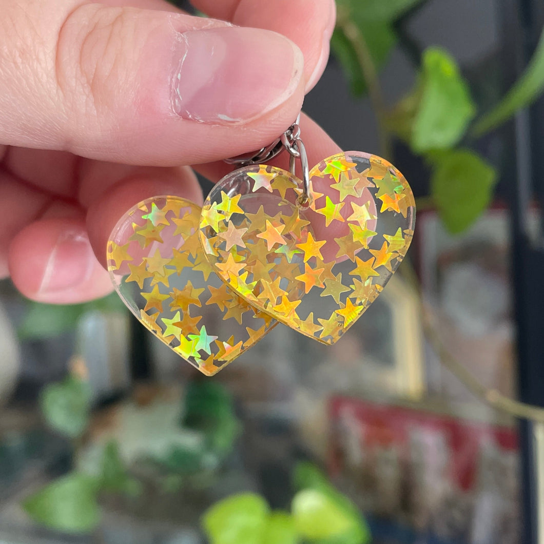 Petites boucles d'oreilles coeurs pendantes en acrylique transparente avec des confettis étoiles