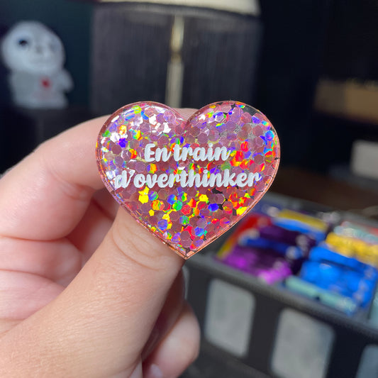 Broche "En train d'overthinker" en acrylique semi transparente avec des confettis corail
