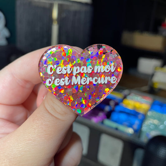 Broche "C'est pas moi c'est Mercure" en acrylique semi transparente avec des confettis corail