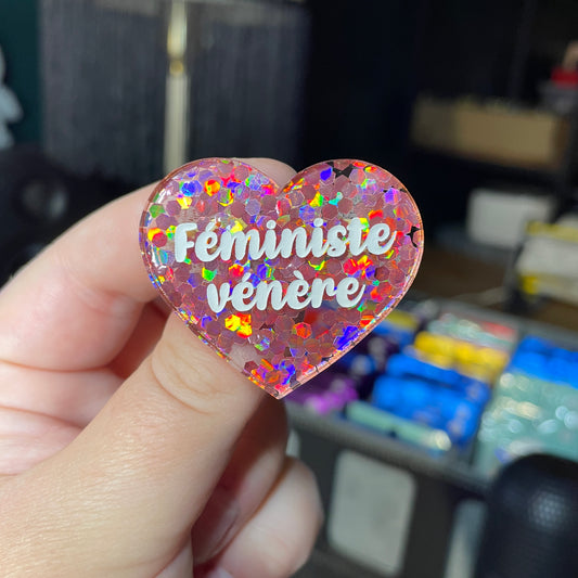 Broche "Féministe vénère" en acrylique semi transparente avec des confettis corail