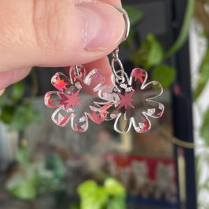 Petites boucles d'oreilles fleurs pendantes en acrylique transparente avec des confettis argentés et étoilés rouges
