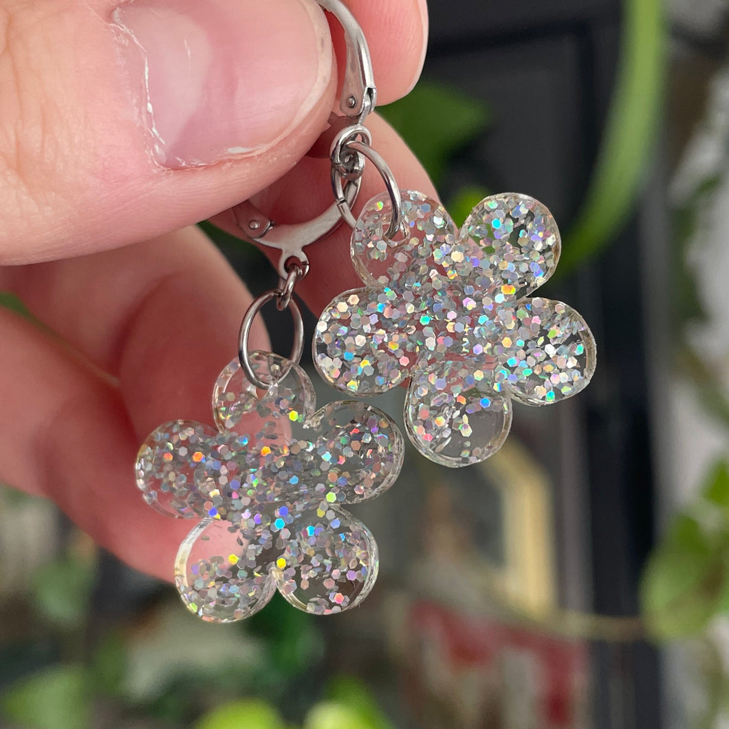 Petites boucles d'oreilles fleurs pendantes en acrylique transparente avec des confettis argentés