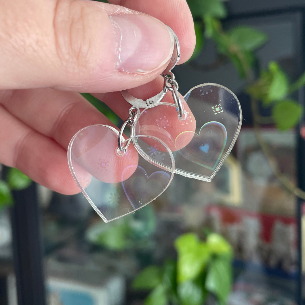 Petites boucles d'oreilles coeurs pendantes en acrylique transparente avec des coeurs iridescents