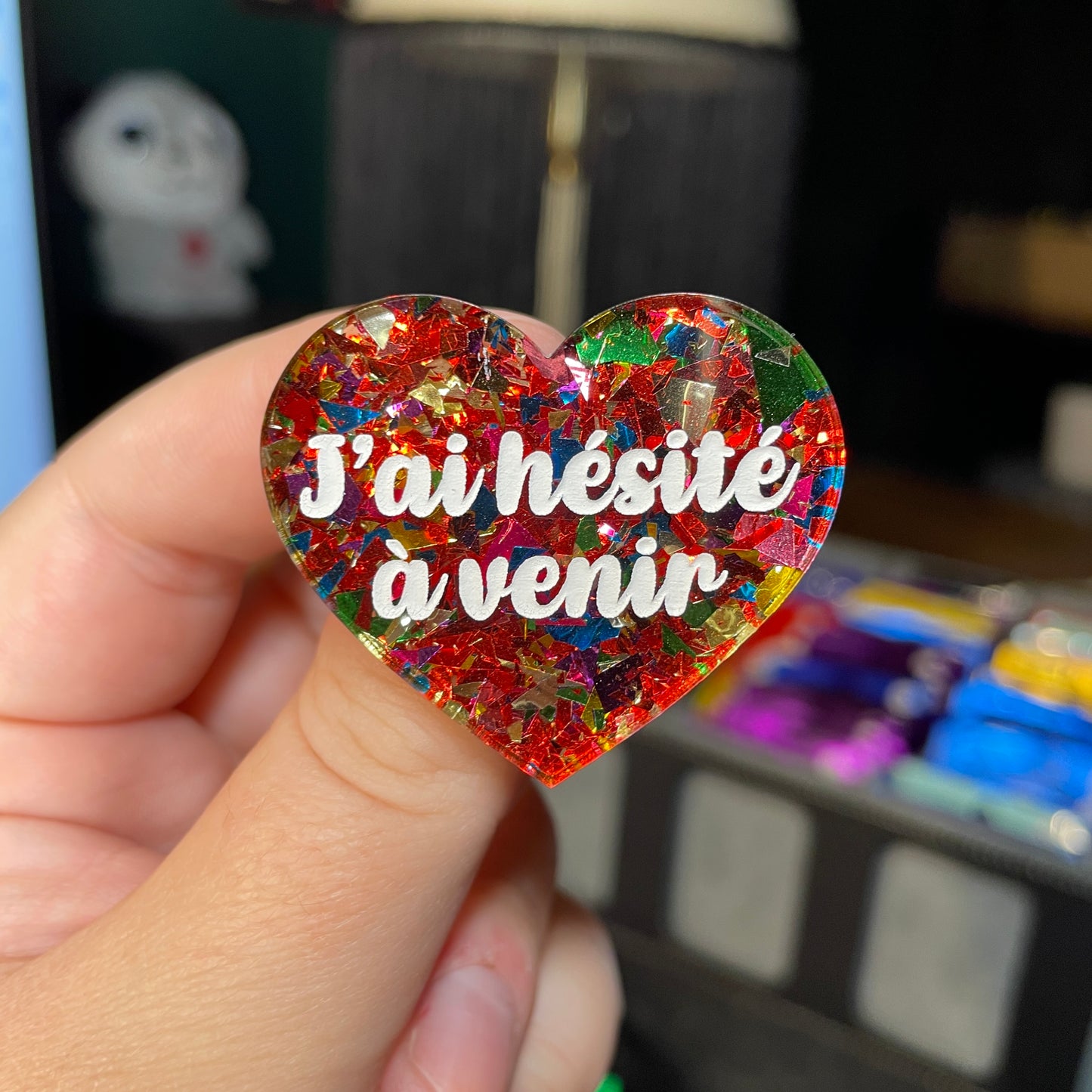 Broche "J'ai hésité à venir" en acrylique transparente avec des éclats de confettis rouges et multicolores