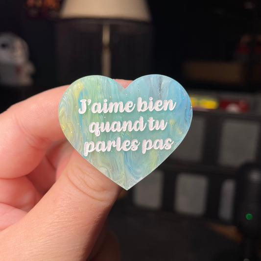 Broche "J'aime bien quand tu parles pas" en acrylique semi transparente marbrée bleue et jaune à paillettes