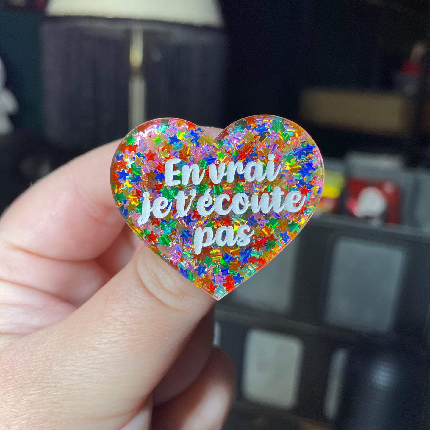 Broche "En vrai je t'écoute pas" en acrylique semi transparente avec des étoiles multicolores