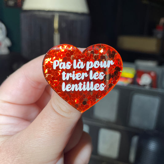Broche "Pas là pour trier les lentilles" en acrylique semi transparente avec des confettis rouges