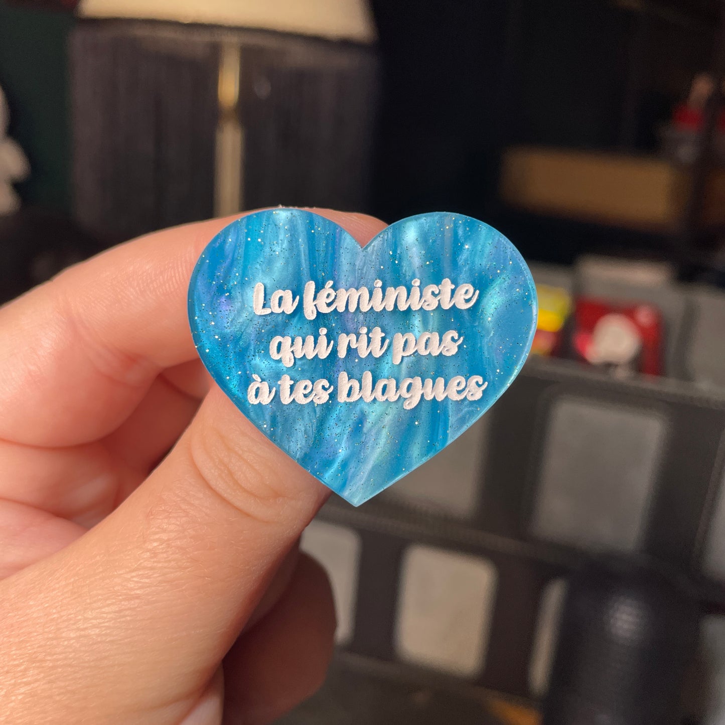 Broche "La féministe qui rit pas à tes blagues" en acrylique marbrée bleue à paillettes