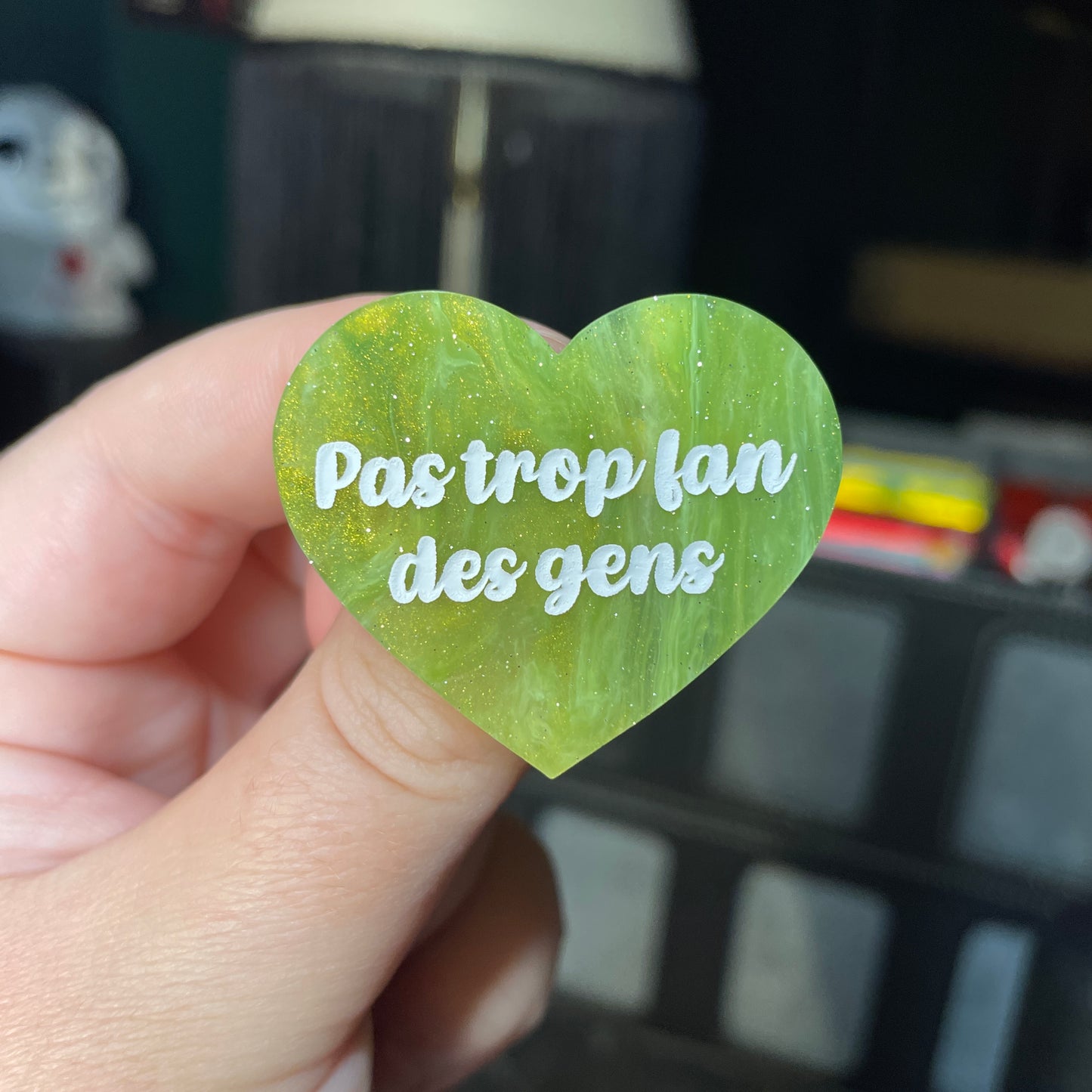 Broche "Pas trop fan des gens" en acrylique semi transparente marbrée verte et dorée à paillettes